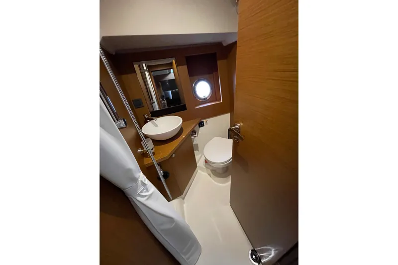  Yacht Photos Pics Bathroom interior of 2025 Beneteau Swift Trawler 41 Fly, featuring modern fixtures and porthole.