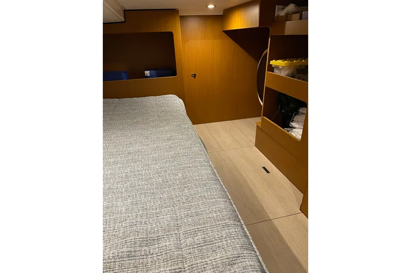  Yacht Photos Pics 2025 Beneteau Swift Trawler 41 Fly cabin interior with bed and wooden storage shelves.
