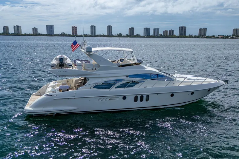 To Life! Yacht Photos Pics 2005 Azimut Fly 62 yacht cruising on open water with city skyline in background.