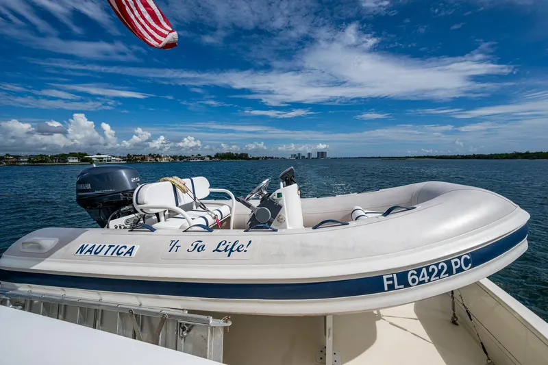 To Life! Yacht Photos Pics A small inflatable boat on water, with "Nautica" and "To Life!" text, under a clear sky.
