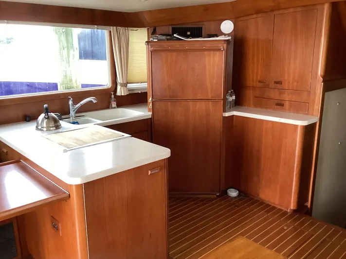 Sea Mist Yacht Photos Pics 1991 MDI Sedan Flybridge interior with wooden cabinetry and modern kitchen amenities.