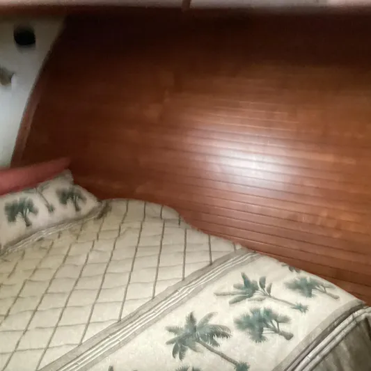 Sea Mist Yacht Photos Pics Cozy cabin interior with wooden paneling and tropical-themed bedding in 1991 MDI Sedan Flybridge.