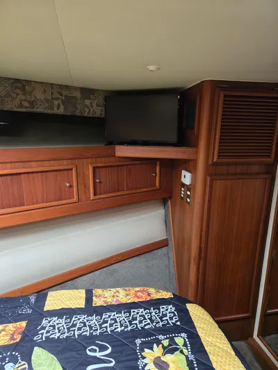 Bad To The Bone Yacht Photos Pics Cozy cabin interior of 1995 Egg Harbor Golden Egg 42 with wood paneling and colorful quilt.