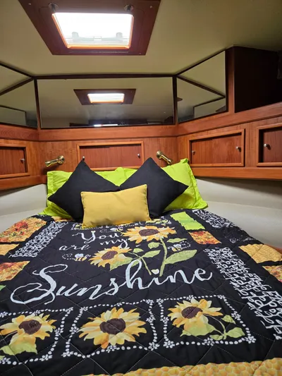 Bad To The Bone Yacht Photos Pics Cozy cabin interior of 1995 Egg Harbor Golden Egg 42 with sunflower-themed bedding.