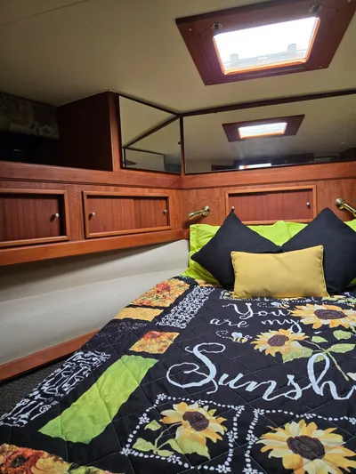 Bad To The Bone Yacht Photos Pics Cozy cabin interior of 1995 Egg Harbor Golden Egg 42 with sunflower-themed bedding.