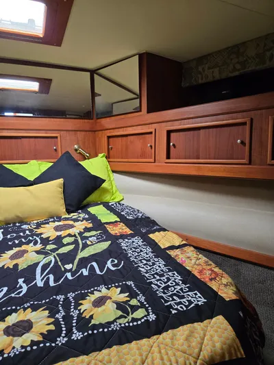 Bad To The Bone Yacht Photos Pics Cozy cabin interior of 1995 Egg Harbor Golden Egg 42 with sunflower-themed bedding.