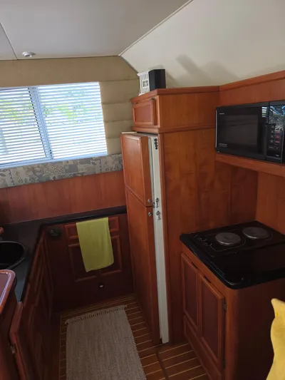 Bad To The Bone Yacht Photos Pics 1995 Egg Harbor Golden Egg 42 yacht kitchen with wood cabinetry, stove, and microwave.