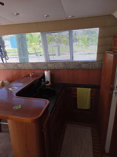 Bad To The Bone Yacht Photos Pics Interior of 1995 Egg Harbor Golden Egg 42 yacht with wooden cabinetry and window blinds.