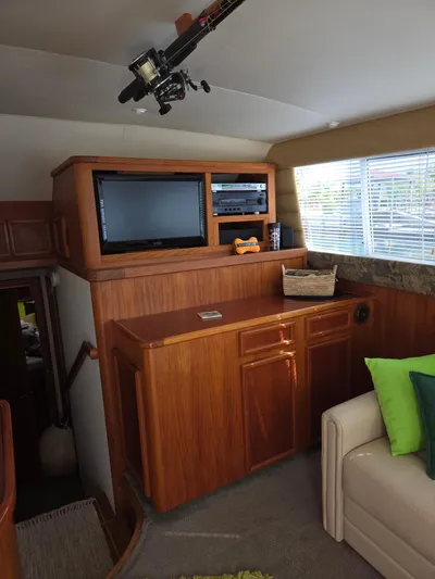 Bad To The Bone Yacht Photos Pics Interior of 1995 Egg Harbor Golden Egg 42 yacht with TV, wooden cabinetry, and fishing rod.