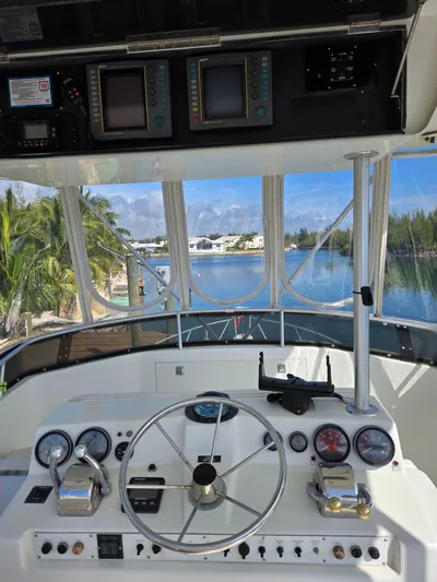 Bad To The Bone Yacht Photos Pics 1995 Egg Harbor Golden Egg 42 yacht helm with navigational instruments and scenic waterway view.