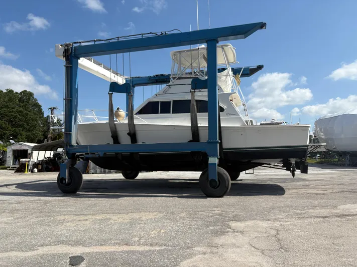 Bad To The Bone Yacht Photos Pics 1995 Egg Harbor Golden Egg 42 yacht on a boat lift under a clear blue sky.