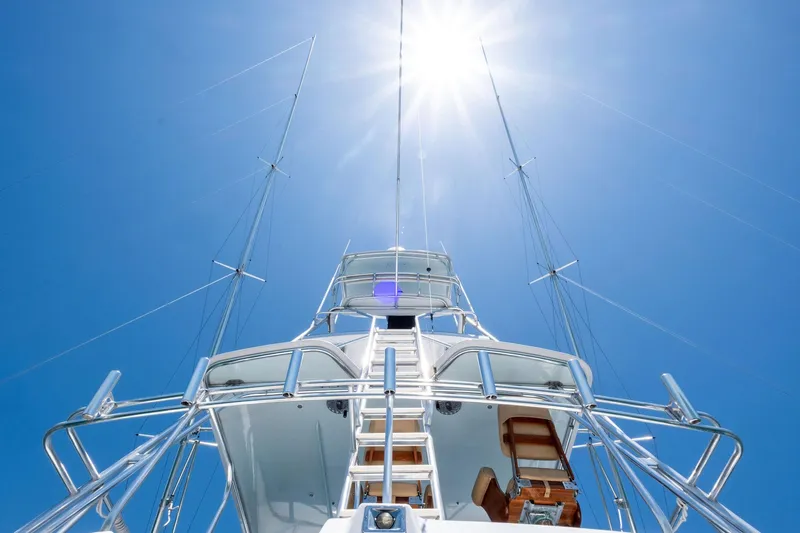 Endurance Yacht Photos Pics 1998 Hatteras 60 Convertible yacht under bright sun, showcasing sleek design and tall masts.