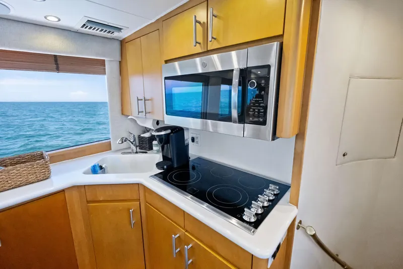 Endurance Yacht Photos Pics Kitchen area of 1998 Hatteras 60 Convertible yacht with ocean view, featuring modern appliances.