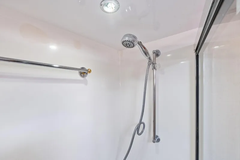 Endurance Yacht Photos Pics Shower area in 1998 Hatteras 60 Convertible yacht, featuring chrome fixtures and glass door.