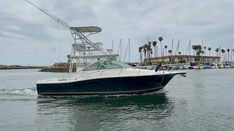 Los Gemelos Yacht Photos Pics 2006 Rampage 33 Express Barta Canyon Edition boat cruising in a marina with palm trees.
