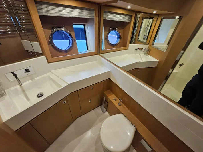  Yacht Photos Pics Luxurious bathroom in 2016 Riva 88' Domino Super yacht with modern fixtures and porthole windows.