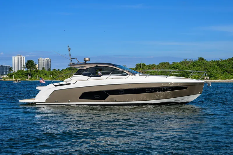 Chloe Yacht Photos Pics 2020 Azimut 45 Atlantis yacht cruising near a lush shoreline with cityscape background.