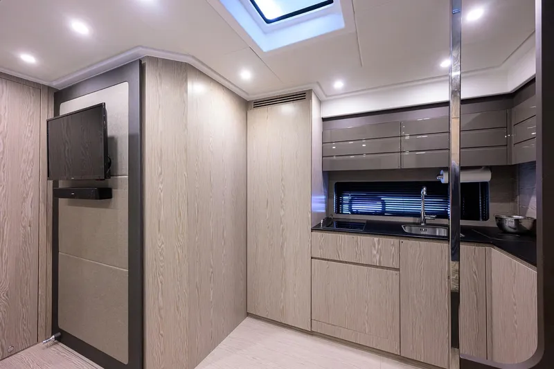 Chloe Yacht Photos Pics Modern interior of 2020 Azimut 45 Atlantis yacht with sleek kitchen and TV setup.