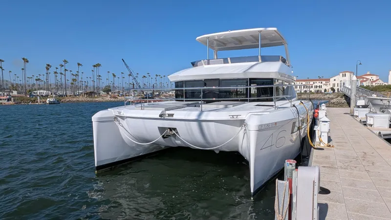 Hamlet Yacht Photos Pics 2023 Leopard Powercat docked at marina, clear sky, palm trees in background.