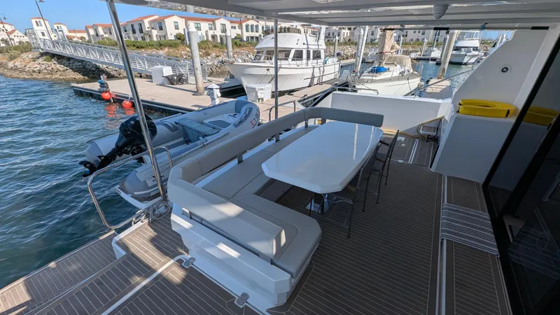 Hamlet Yacht Photos Pics 2023 Leopard Powercat yacht with outdoor seating at a marina dock.