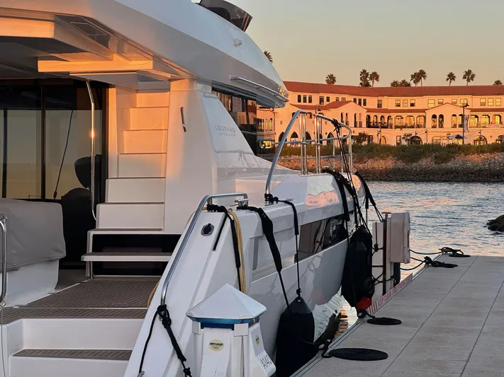 Hamlet Yacht Photos Pics 2023 Leopard Powercat yacht docked at sunset, with elegant architecture in the background.