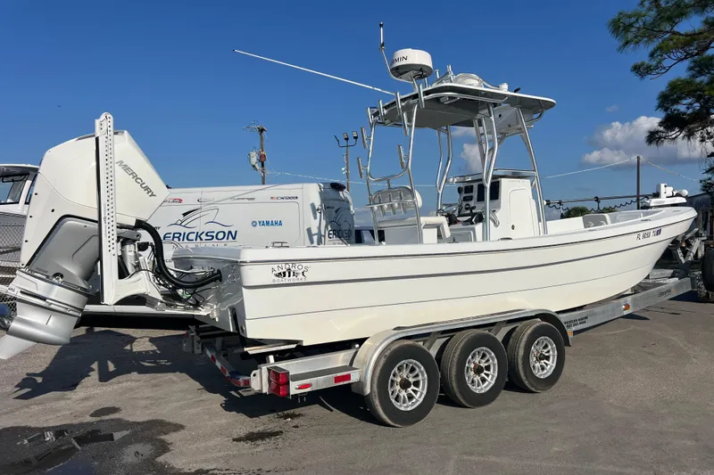  Yacht Photos Pics 2024 Andros Tarpon 26 boat on trailer, featuring Mercury engine, clear sky background.