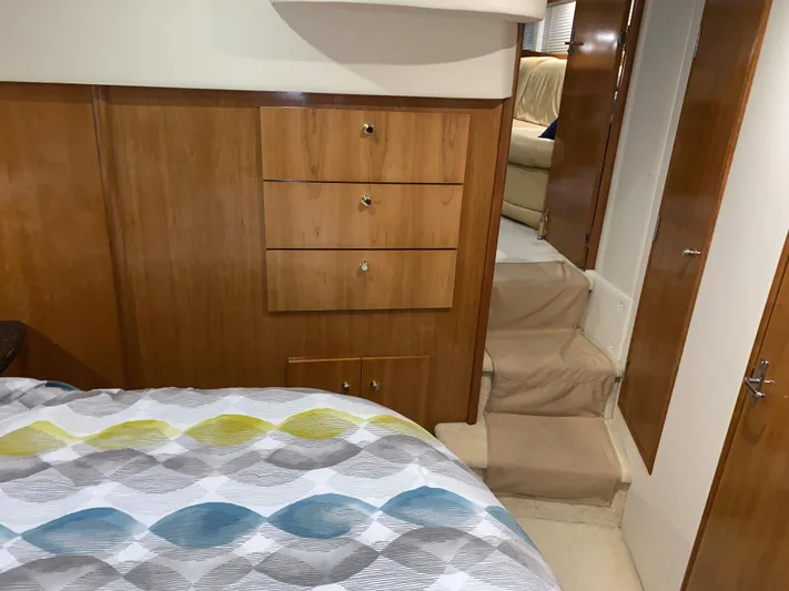 Why Knot Yacht Photos Pics Interior of 2001 Carver 396 Motor Yacht with wooden cabinetry and patterned bedding.