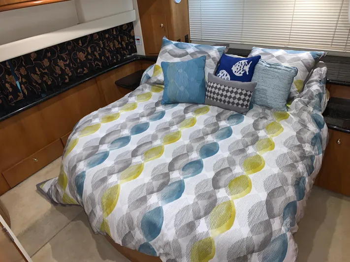 Why Knot Yacht Photos Pics Cozy bedroom in 2001 Carver 396 Motor Yacht with colorful bedding and decorative pillows.