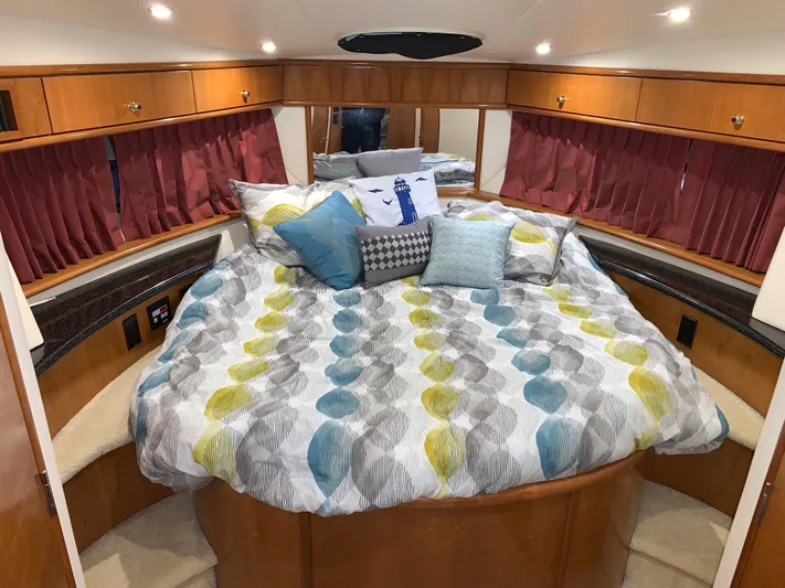 Why Knot Yacht Photos Pics Luxurious bedroom interior of 2001 Carver 396 Motor Yacht with colorful bedding and wood accents.