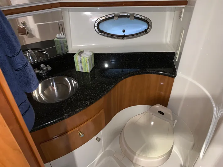 Why Knot Yacht Photos Pics 2001 Carver 396 Motor Yacht bathroom with sink, toilet, and porthole window.