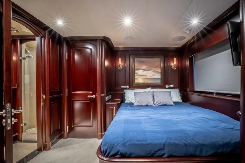 Status Quo Yacht Photos Pics Luxurious yacht bedroom with rich wood paneling, blue bedding, and elegant lighting. Horizon Model Tri-Deck 2009.