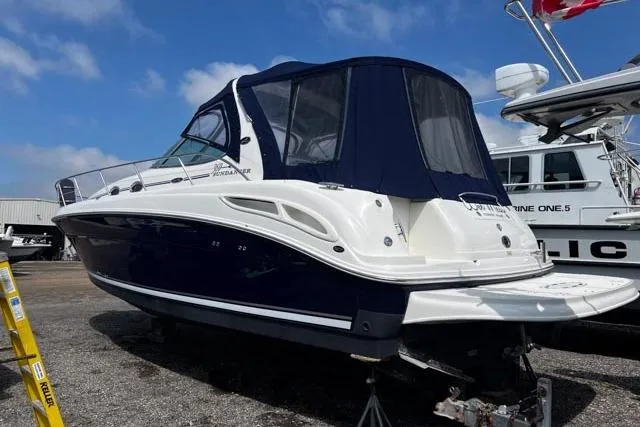Wet Mess Yacht Photos Pics 2004 Sea Ray 360 Sundancer boat with blue canopy, docked on land under a clear sky.