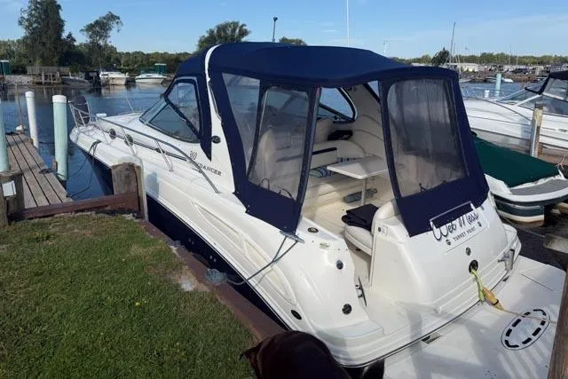 Wet Mess Yacht Photos Pics 2004 Sea Ray 360 Sundancer docked, featuring a blue canopy and spacious deck area.