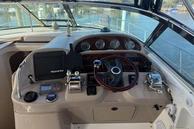 Wet Mess Yacht Photos Pics 2004 Sea Ray 360 Sundancer helm with steering wheel, gauges, and navigation equipment.