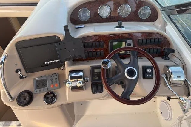 Wet Mess Yacht Photos Pics Helm of 2004 Sea Ray 360 Sundancer with Raymarine electronics and wood-accented steering wheel.
