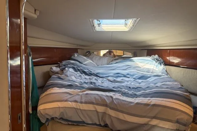 Wet Mess Yacht Photos Pics Interior cabin of 2004 Sea Ray 360 Sundancer with striped bedding and overhead hatch.