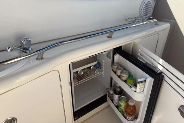 Wet Mess Yacht Photos Pics 2004 Sea Ray 360 Sundancer boat kitchenette with open mini fridge and beverages.