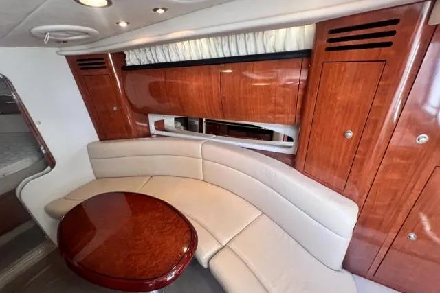 Wet Mess Yacht Photos Pics Luxurious interior of 2004 Sea Ray 360 Sundancer with elegant wood finish and curved seating.