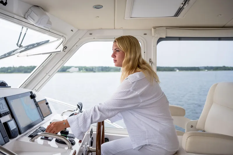 Dayglow Yacht Photos Pics Woman piloting 2020 MJM 53z yacht on open water.