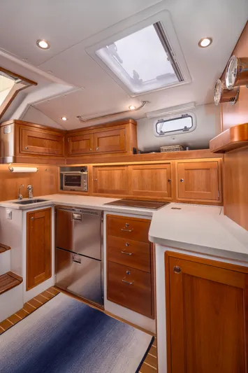 Dayglow Yacht Photos Pics Luxurious 2020 MJM 53z yacht kitchen with wooden cabinetry and modern appliances.