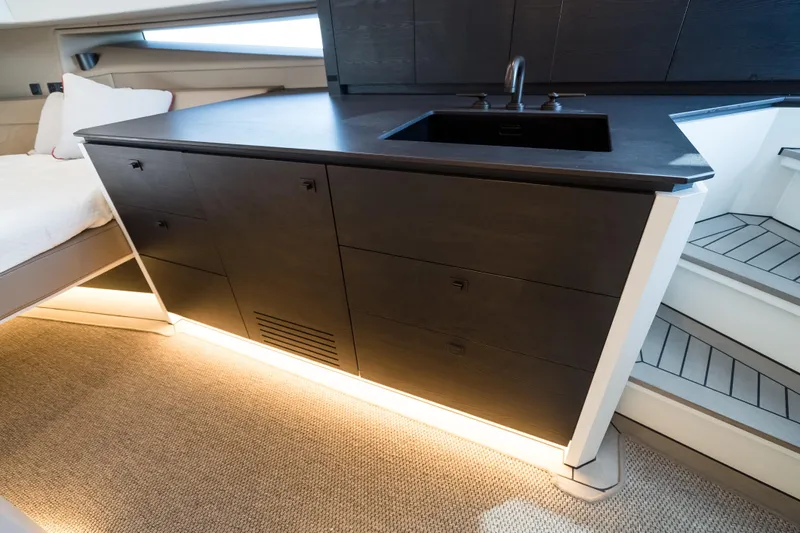 Robin's Nest Yacht Photos Pics Luxurious interior of 2023 Vanquish Yachts VQ45 Veloce Hardtop with sleek cabinetry and modern sink.