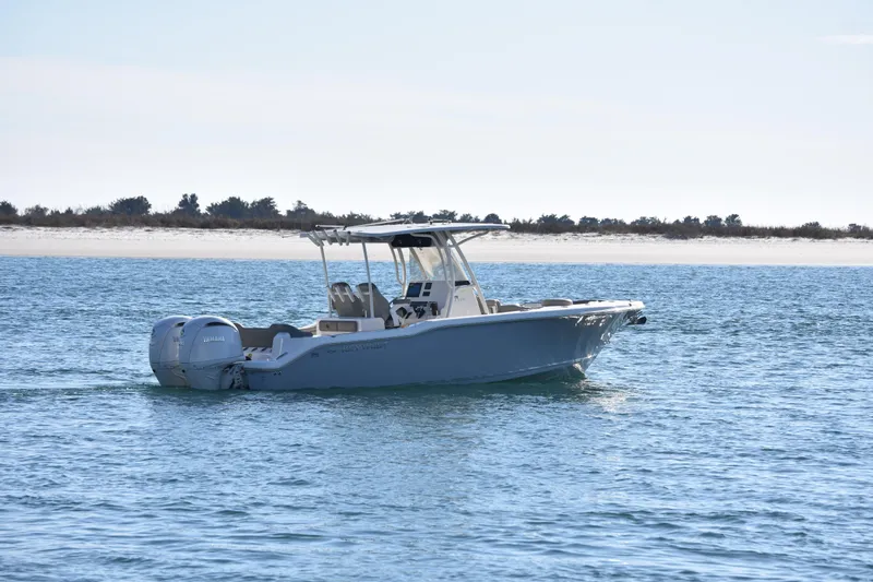  Yacht Photos Pics 2024 Key West 263 FS boat cruising on calm blue waters near a sandy shoreline.