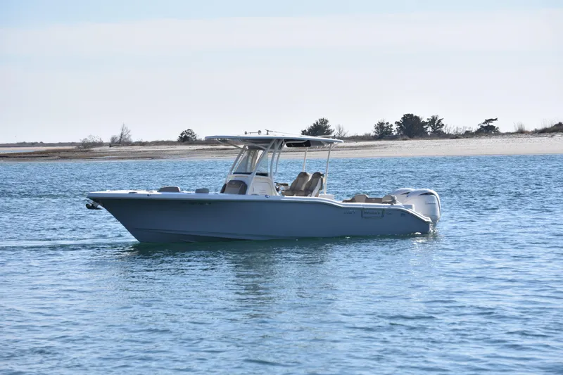  Yacht Photos Pics 2024 Key West 263 FS boat cruising on calm waters near a sandy shoreline.