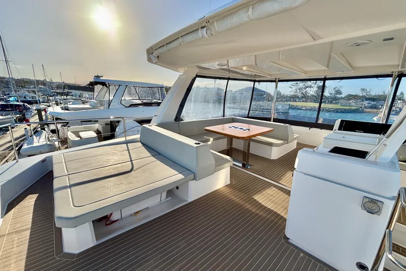  Yacht Photos Pics 2022 Leopard 46 Powercat yacht interior with seating and table, docked at marina.
