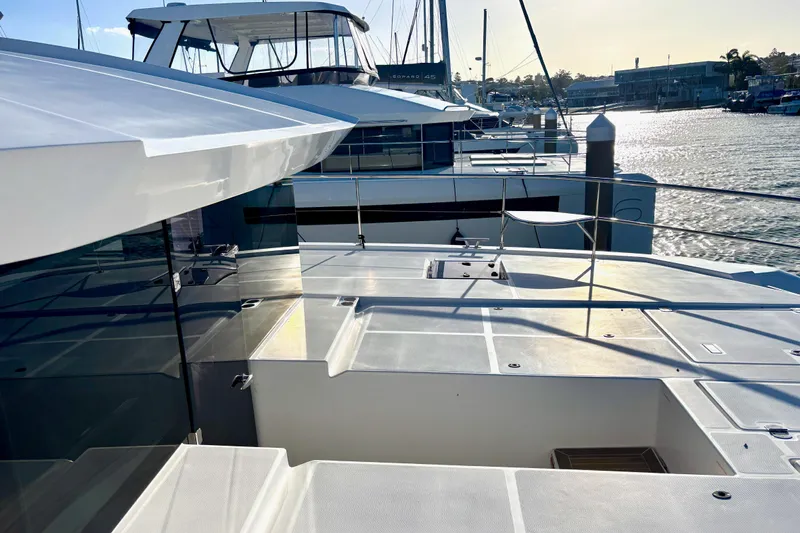  Yacht Photos Pics 2022 Leopard 46 Powercat yacht docked at marina, showcasing sleek design and spacious deck.