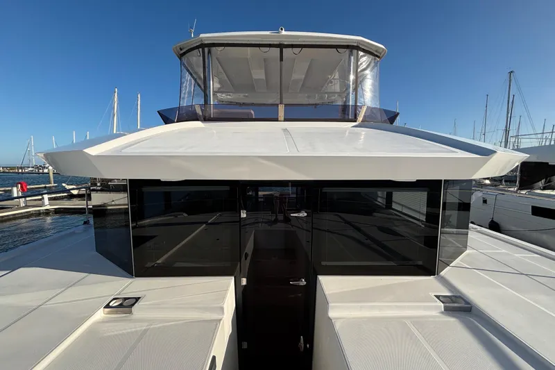  Yacht Photos Pics 2022 Leopard 46 Powercat yacht with sleek design, docked at marina under clear blue sky.