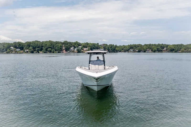  Yacht Photos Pics 2023 Fountain 38 SC boat on a calm lake with scenic shoreline.