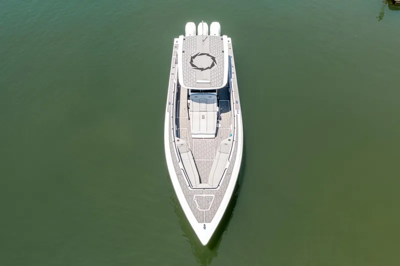  Yacht Photos Pics 2023 Fountain 38 SC boat, aerial view, on calm green water.