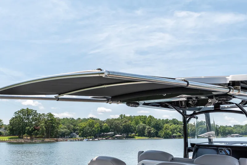  Yacht Photos Pics 2023 Fountain 38 SC boat with canopy on a serene lake.