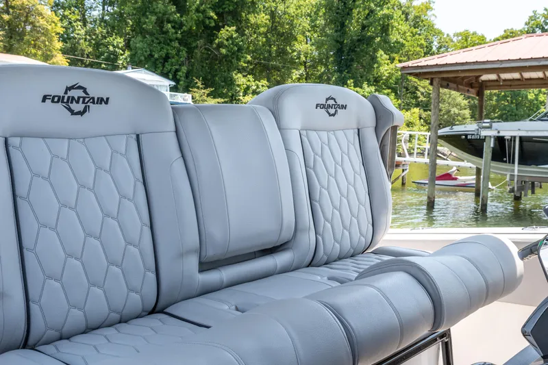  Yacht Photos Pics 2023 Fountain 38 SC boat seats with quilted design, docked near a lakeside.